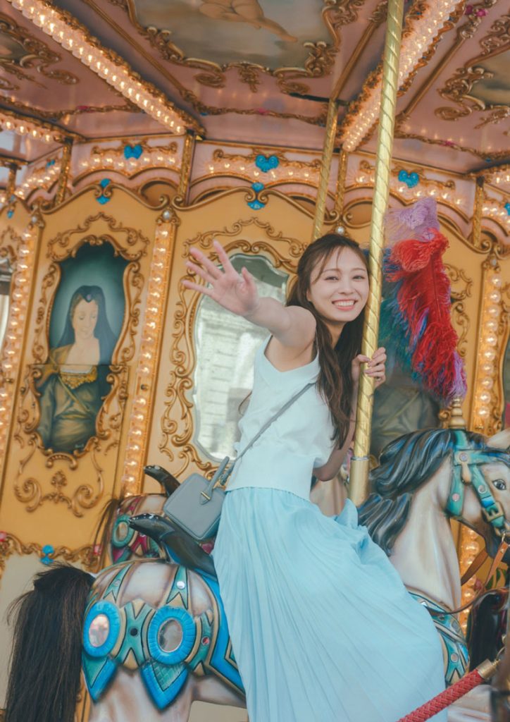 乃木坂46・梅澤美波2nd写真集『透明な覚悟』(光文社)よりフィレンツェの凱旋門前にあるメリーゴーランドに乗ってご機嫌な1コマ