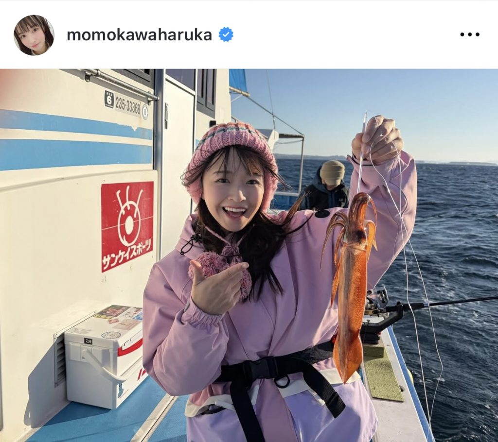 イカを釣り上げ笑顔を見せる